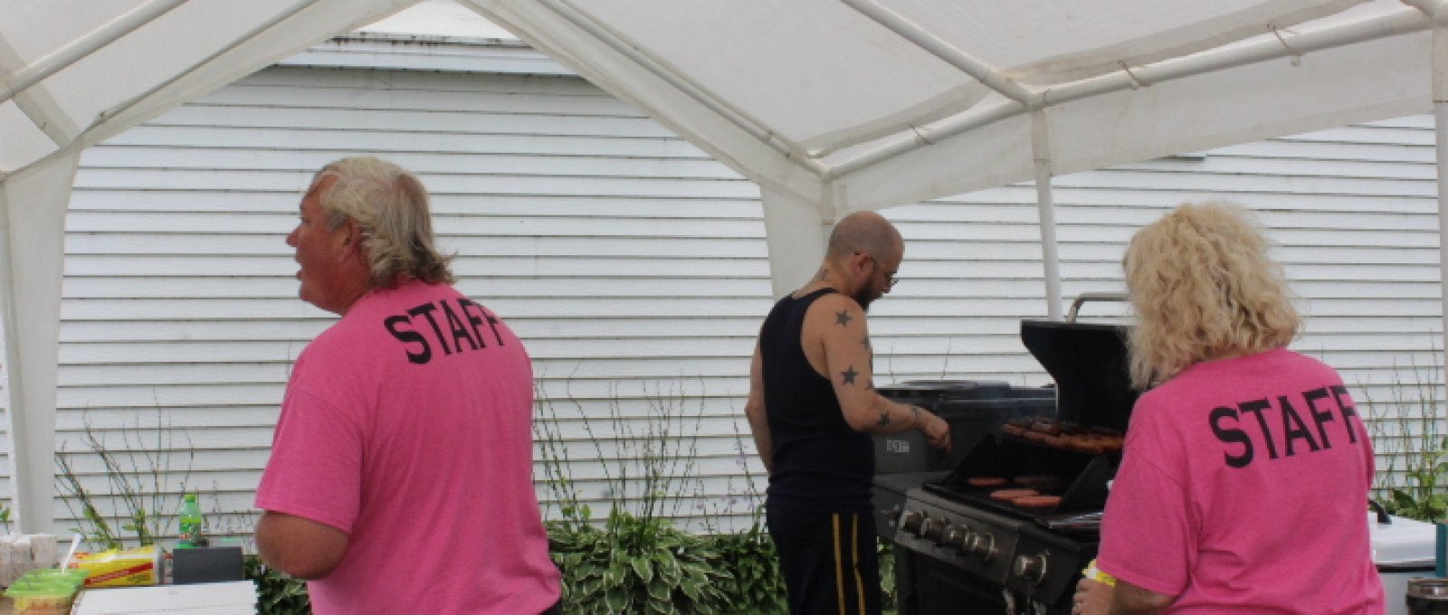 Billy Z. on the grill while Tim and Nicole serve the food.
